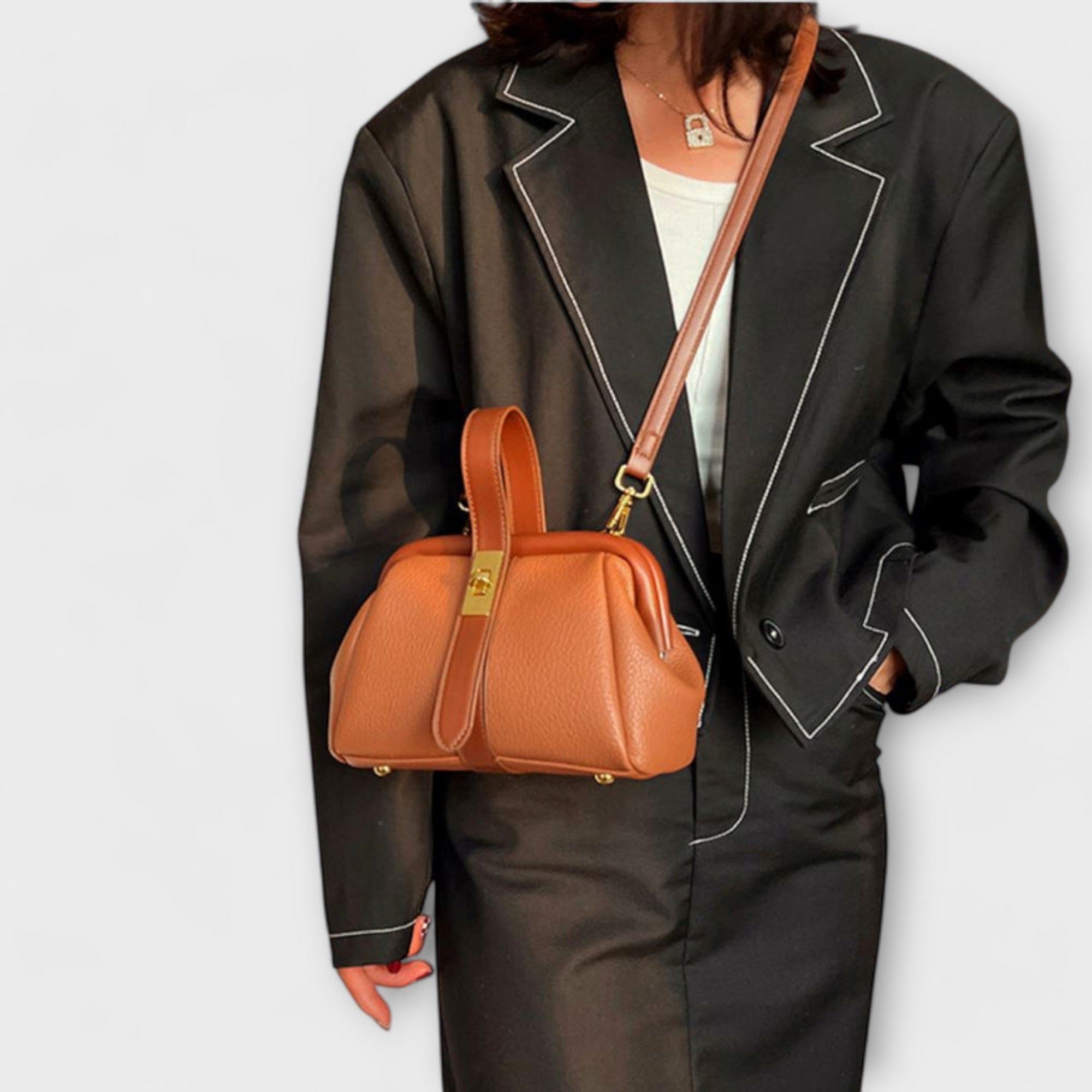 Geantă de mână sau crossbody damă Angie, culoare maro, purtată de o femeie elegant îmbrăcată.